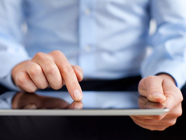 business professional interacting with a tablet touchscreen