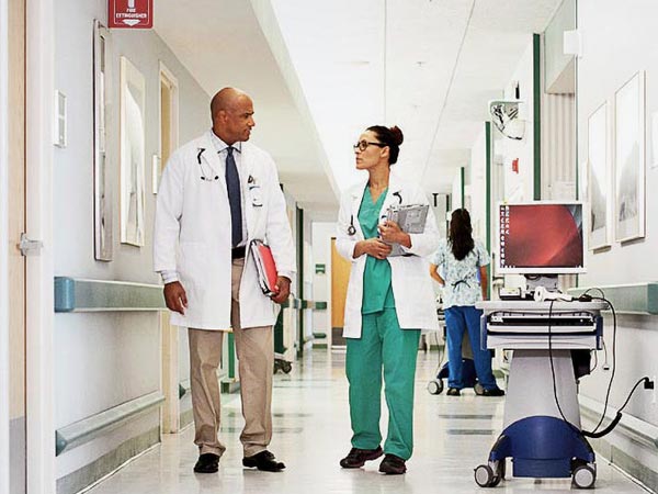 Medical professionals walking in a hospital corridor, discussing patient care